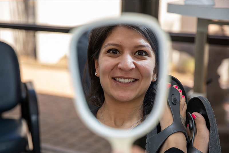 Patient smiling confidently in the mirror after their dental procedure